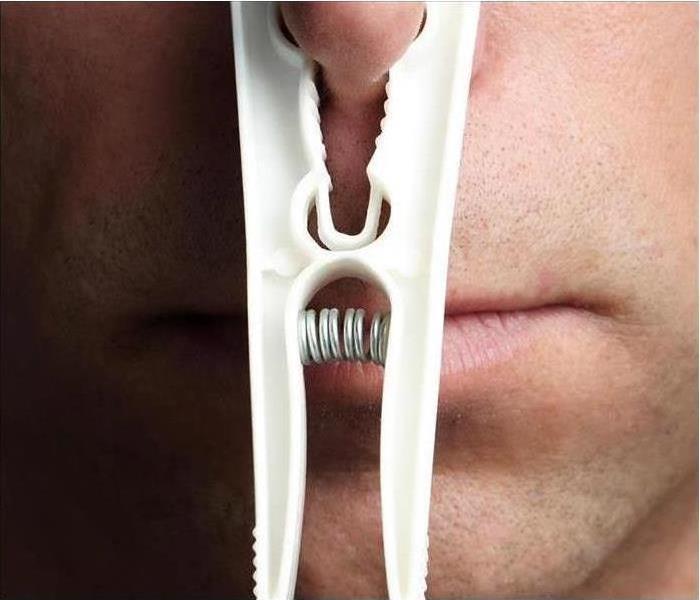 man with clothespin on nose